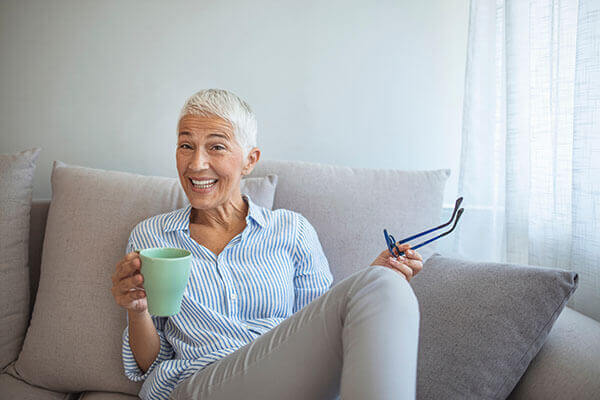 Woman Holding Coffee Sitting on a Couch